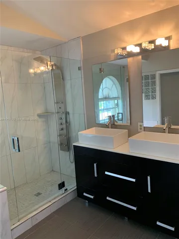 a bathroom with a shower sink and mirror