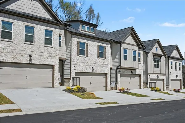 a front view of a house with yard and parking