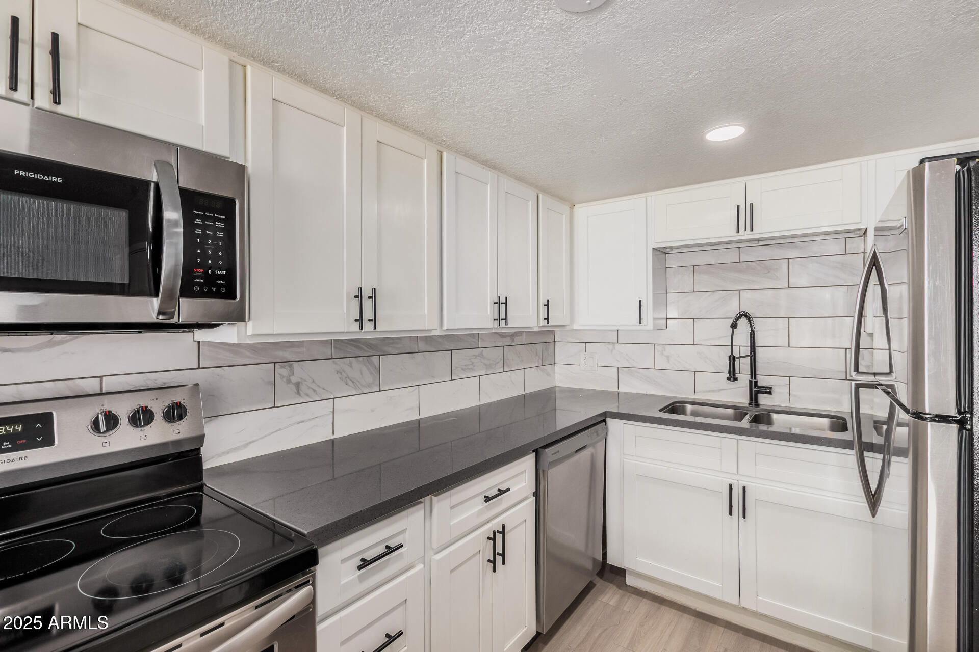 1804 West Tuckey Lane, Unit 1 Phoenix, AZ 85015 - Photo 12 of 25 a kitchen with granite countertop a sink cabinets and stainless steel appliances