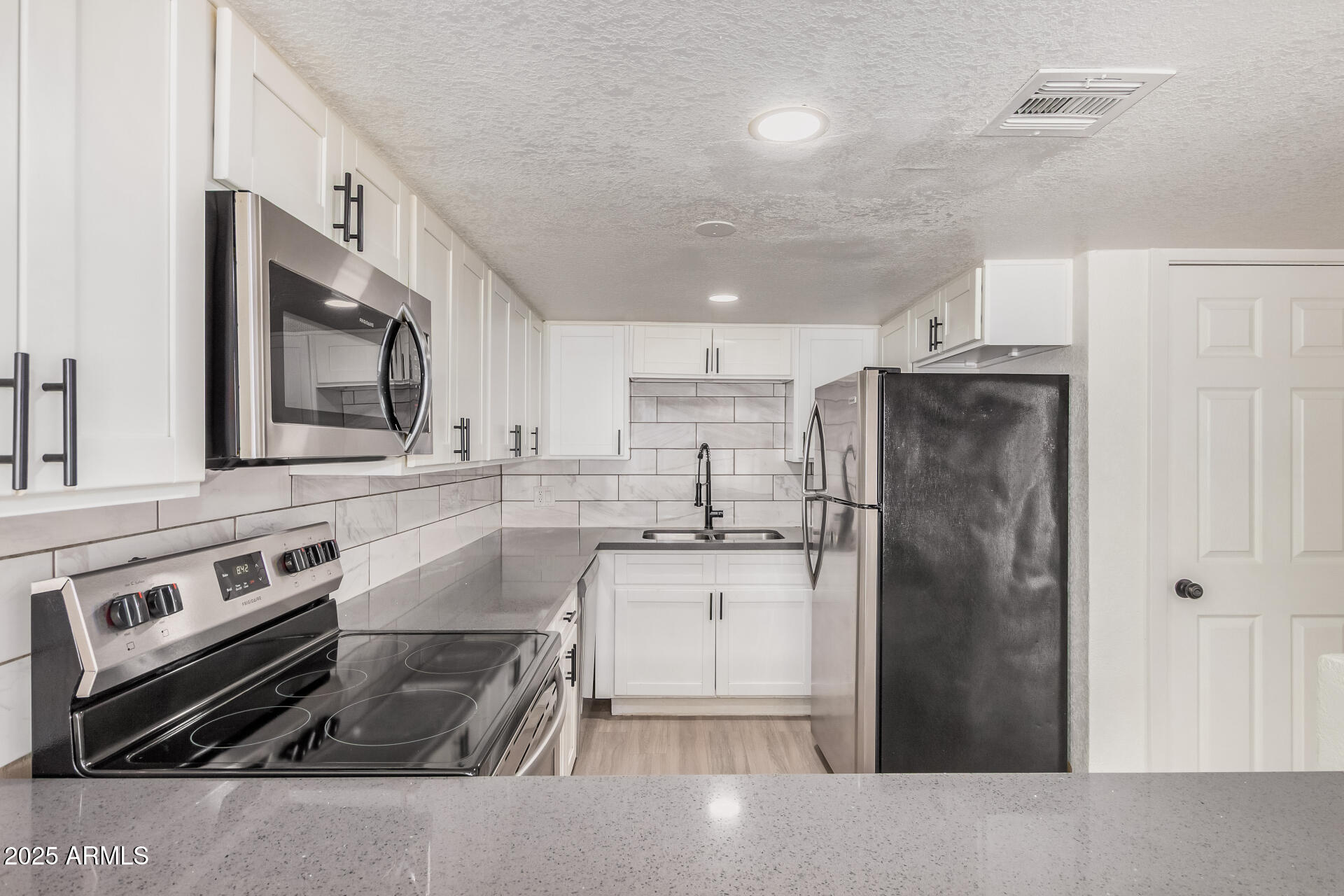 1804 West Tuckey Lane, Unit 1 Phoenix, AZ 85015 - Photo 13 of 25 a kitchen with granite countertop a refrigerator stove and sink
