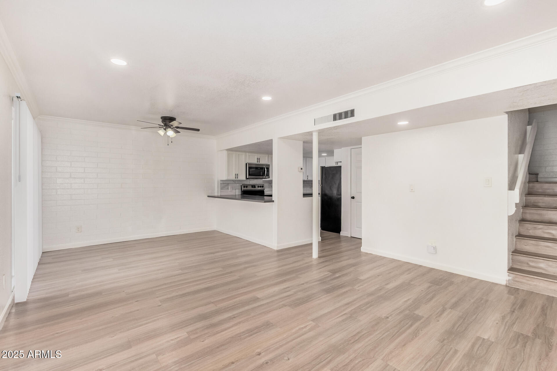 1804 West Tuckey Lane, Unit 1 Phoenix, AZ 85015 - Photo 8 of 25 a view of an empty room with wooden floor kitchen and a window