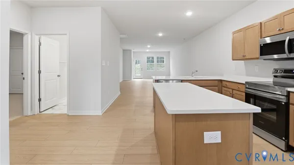 a kitchen with stainless steel appliances granite countertop a sink a stove top oven a counter space and cabinets