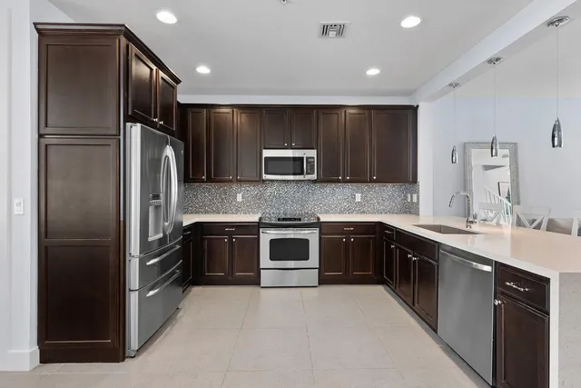 a kitchen with stainless steel appliances granite countertop a refrigerator and a sink