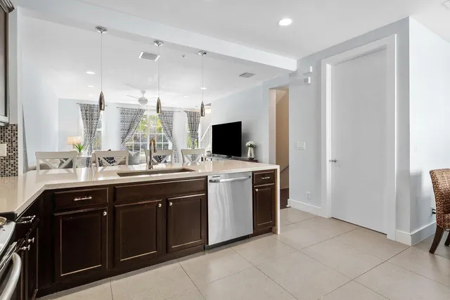 a view of a kitchen with kitchen island a sink stainless steel appliances and cabinets