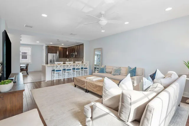 a living room with furniture and a view of kitchen