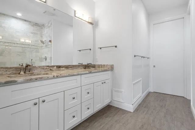 a bathroom with a granite countertop sink and a mirror