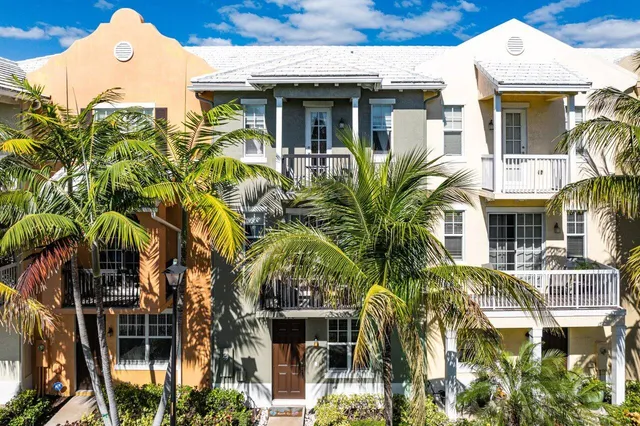 a front view of multiple houses with a garden