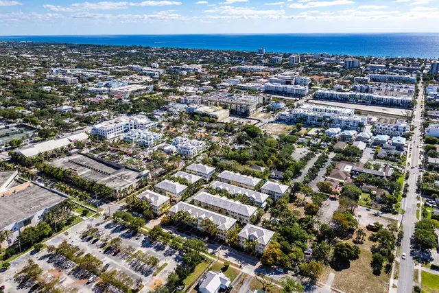 a aerial view of multi story residential apartment building with yard and outdoor seating