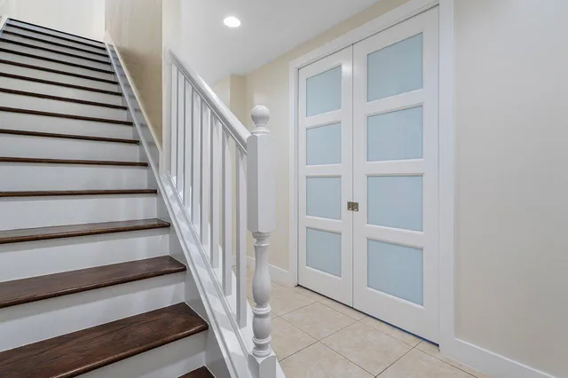 a view of staircase with wooden floor and white walls