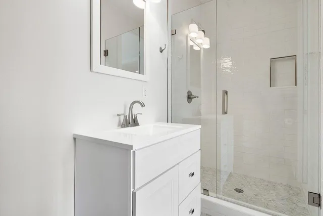 a bathroom with a sink a mirror and shower