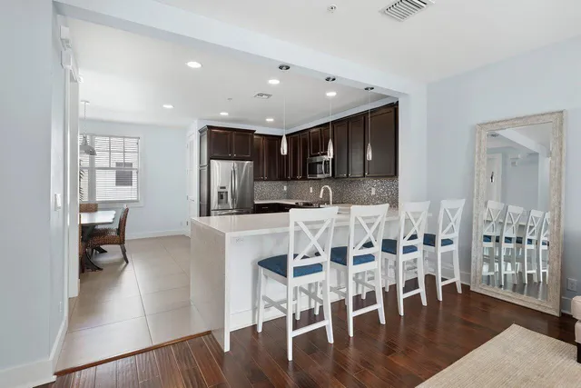 a kitchen with stainless steel appliances kitchen island granite countertop a refrigerator and a stove top oven