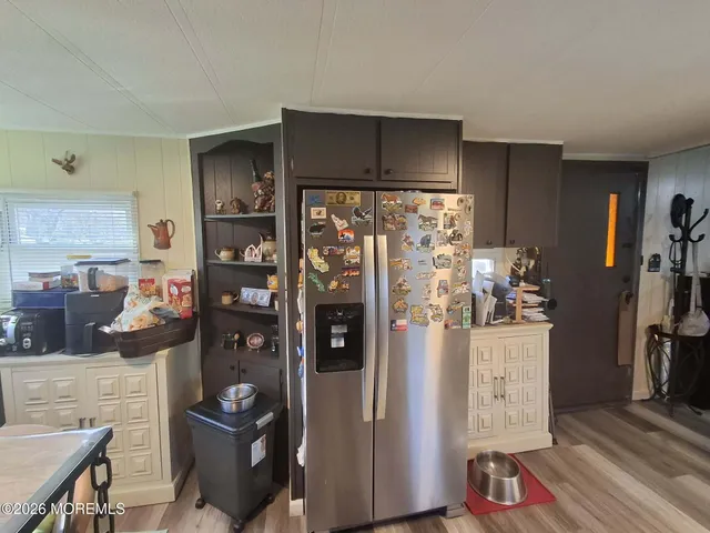 a view of a kitchen with fridge and workspace