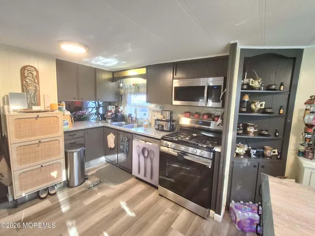 a kitchen with granite countertop a refrigerator stove and sink