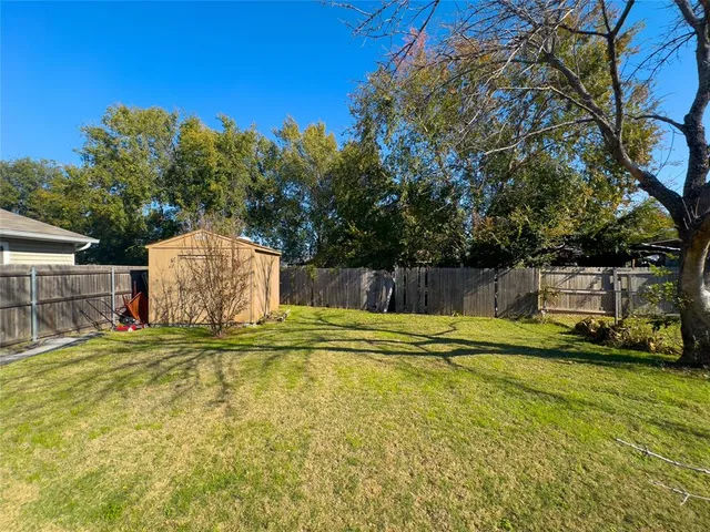 a swimming pool with yard and trees in the background