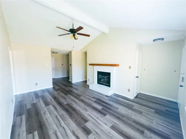 a view of empty room with wooden floor and fireplace