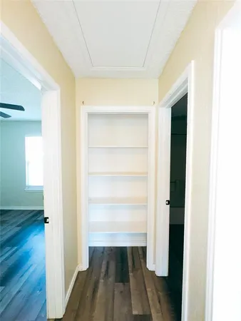 a view of a room with wooden floor closet and windows