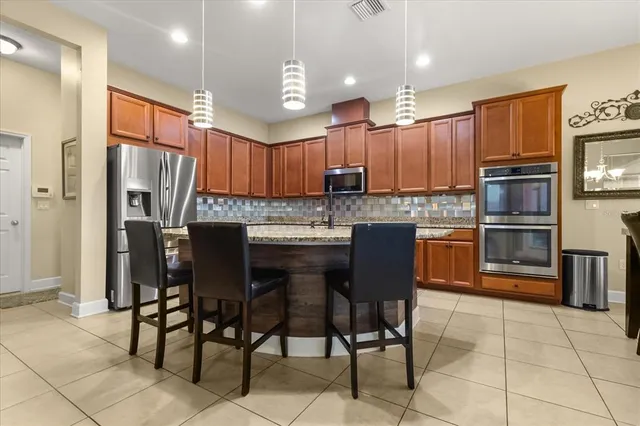 a kitchen with stainless steel appliances granite countertop a stove a sink refrigerator and microwave