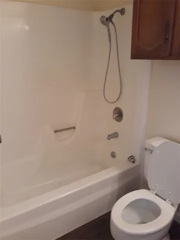 a bathroom with a toilet and a bath tub