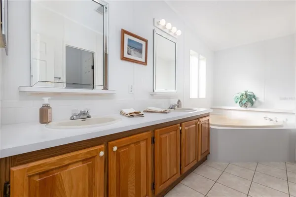 a bathroom with a granite countertop sink and a bathtub