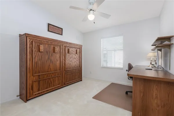 a view of a workspace with furniture and a window