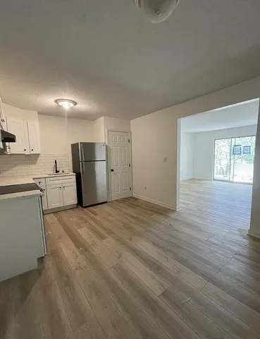 a view of a kitchen with a sink and a refrigerator