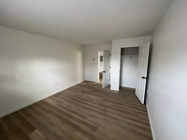 a view of empty room with wooden floor