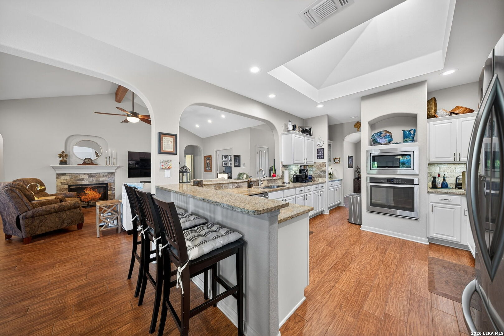 9331 Tyler Oaks Helotes, TX 78023 - Photo 12 of 47 a kitchen with stainless steel appliances kitchen island granite countertop a table chairs and a refrigerator