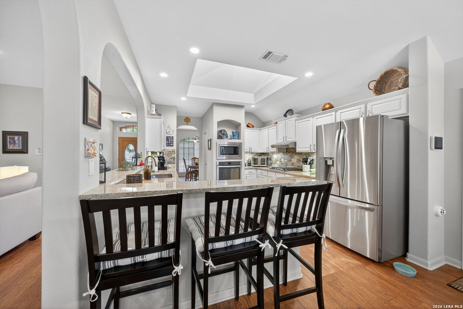 9331 Tyler Oaks Helotes, TX 78023 - Photo 16 of 47 a kitchen with stainless steel appliances a dining table chairs and wooden floor