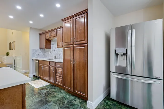 a kitchen with stainless steel appliances granite countertop a refrigerator and a sink