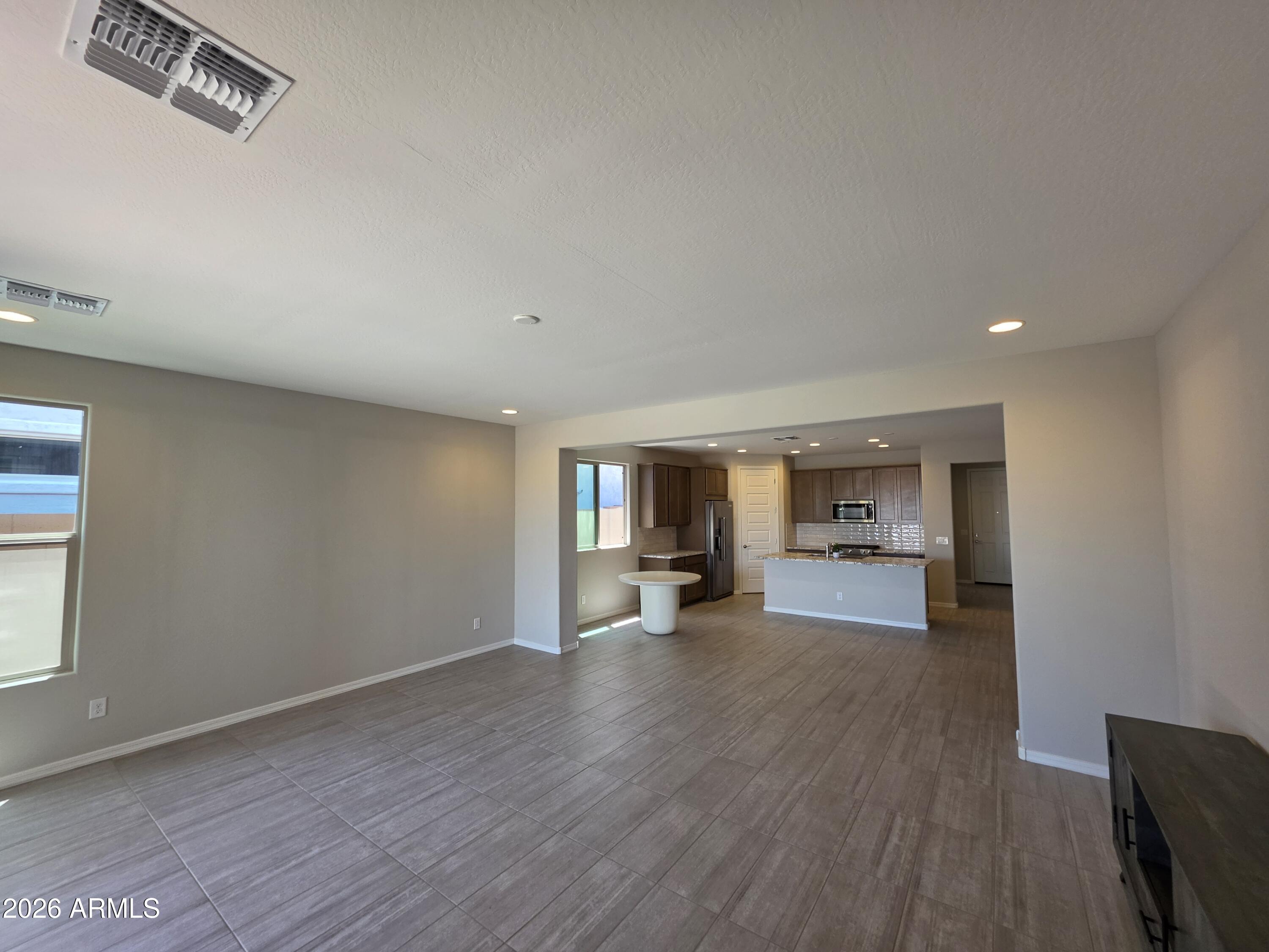 7128 West Coles Road Laveen, AZ 85339 - Photo 7 of 38 a view of a livingroom and a kitchen with wooden floor and a window