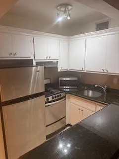 a kitchen with granite countertop a sink and a refrigerator