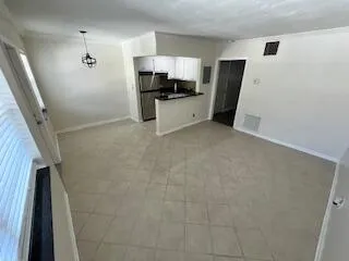 a view of a kitchen with fridge and wooden floor