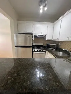 a kitchen with kitchen island a sink stainless steel appliances and cabinets