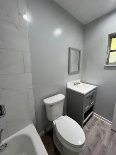 a bathroom with a toilet sink and mirror