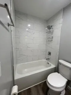 a white bath tub sitting next to a white toilet