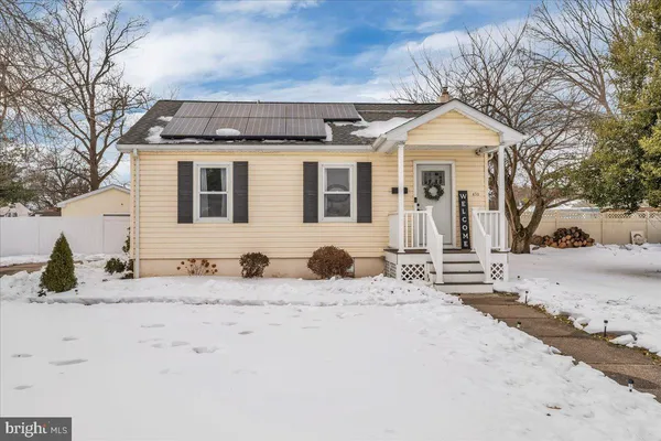 a front view of a house with snow on road