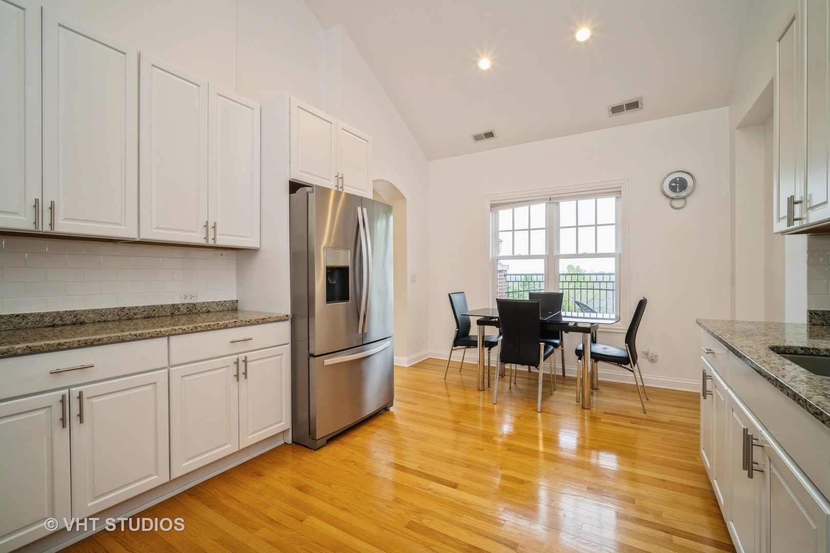 2365 Waukegan Road, Unit 3D Northbrook, IL 60062 - Photo 8 of 21 a kitchen with stainless steel appliances granite countertop a stove top oven a sink a dining table and chairs with wooden floor