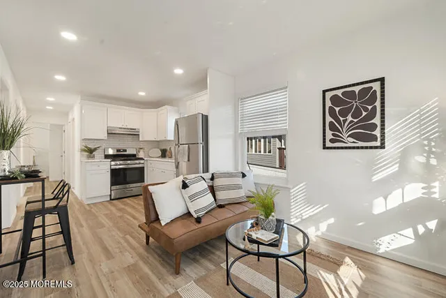 a living room with furniture and kitchen view
