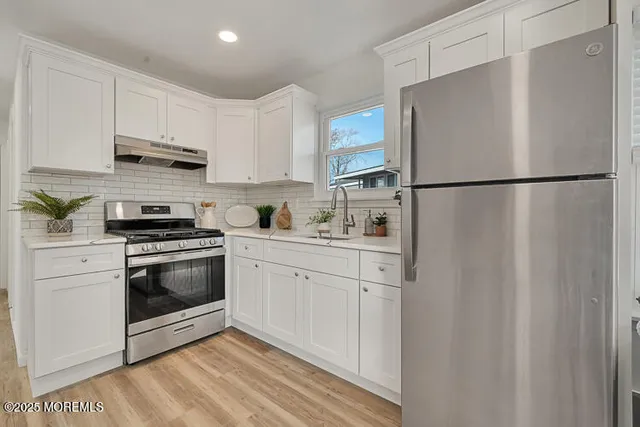a kitchen with white cabinets and stainless steel appliances