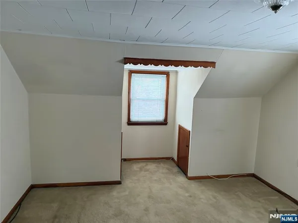 an empty room with wooden floor and mirror
