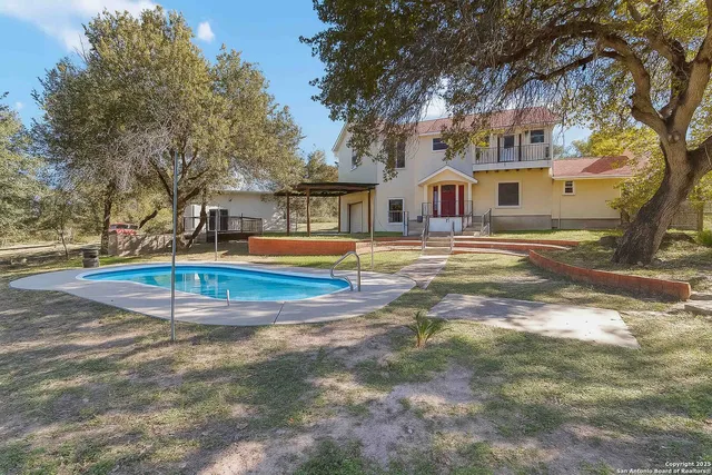 a backyard of a house with a large tree