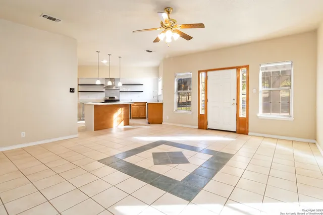 an empty room with windows and ceiling fan view