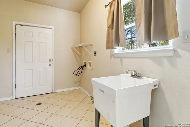 a kitchen with white cabinets and chandelier