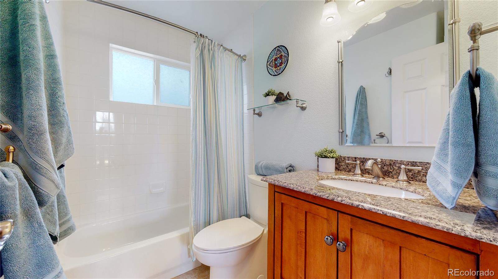 Undisclosed Address Longmont, CO 80504 - Photo 29 of 40 a bathroom with a granite countertop sink toilet and shower