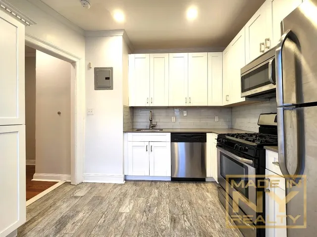 a kitchen with stainless steel appliances granite countertop a stove a sink and a refrigerator