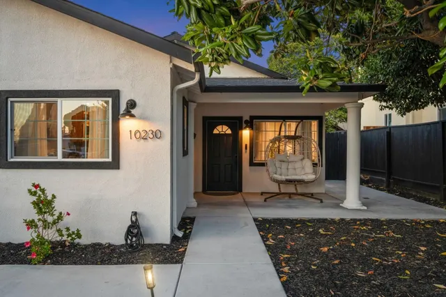 a front view of a house with potted plants