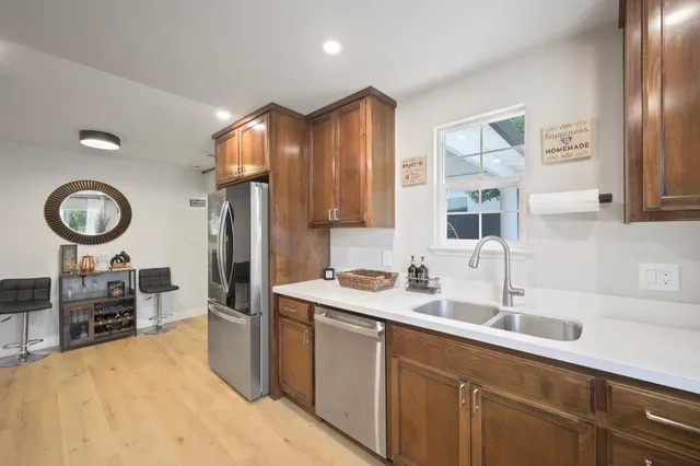 a kitchen with stainless steel appliances a sink a stove and a refrigerator