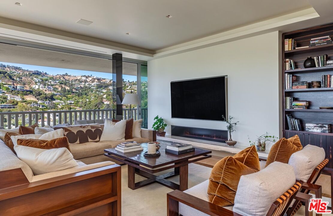 a living room with furniture a flat screen tv and a floor to ceiling window
