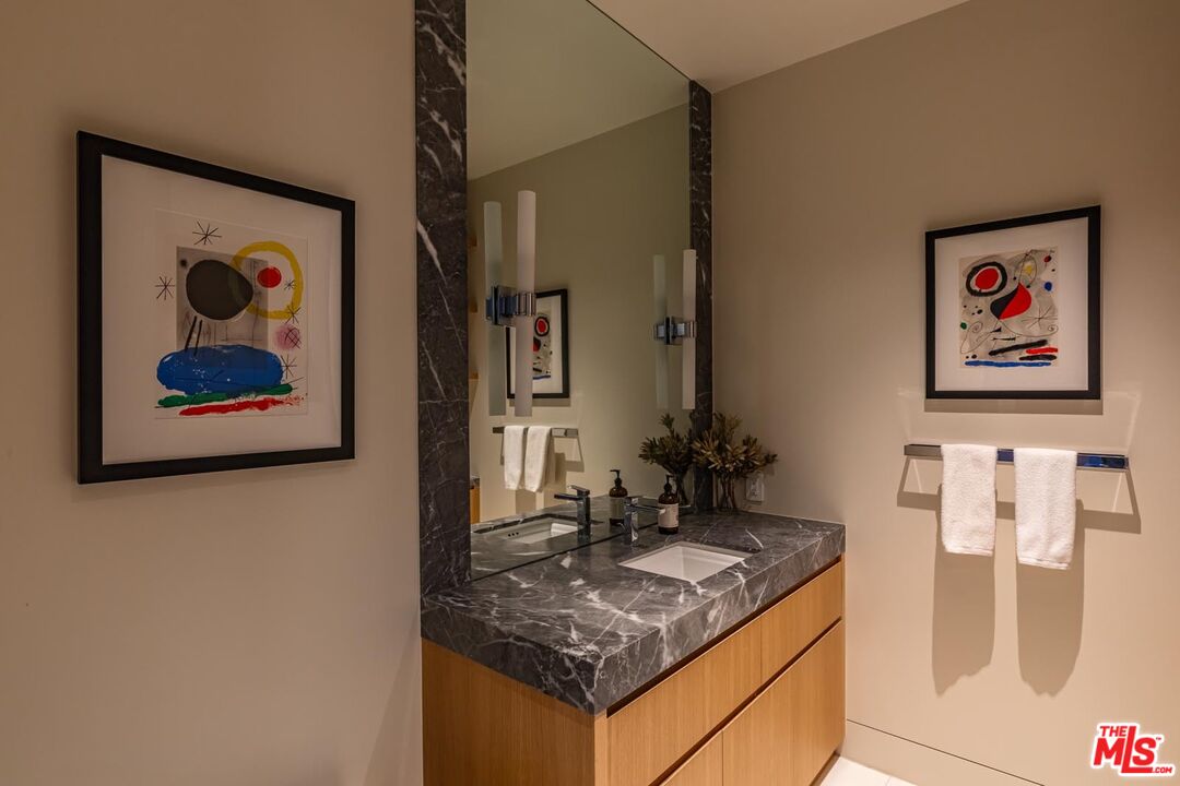 9255 Doheny Road, Unit 1901 West Hollywood, CA 90069 - Photo 13 of 23 a bathroom with a granite countertop sink a mirror and vanity
