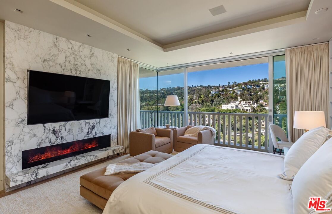 9255 Doheny Road, Unit 1901 West Hollywood, CA 90069 - Photo 15 of 23 a bedroom with furniture a flat screen tv and a floor to ceiling window